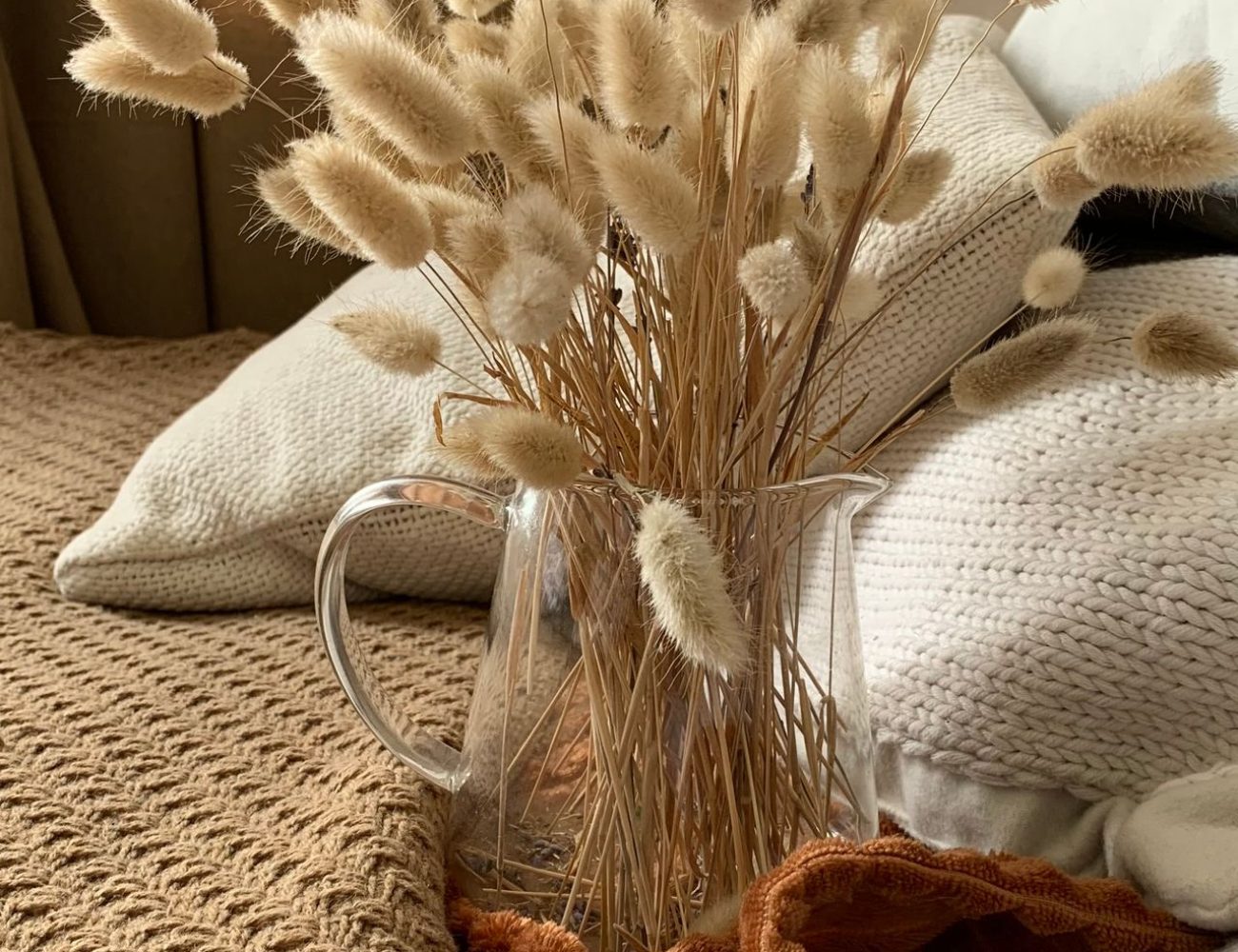 Gemütliche Sitzecke mit weichen Strickdecken und warmen Naturtönen als Inspiration für eine bewusste Winterauszeit.
